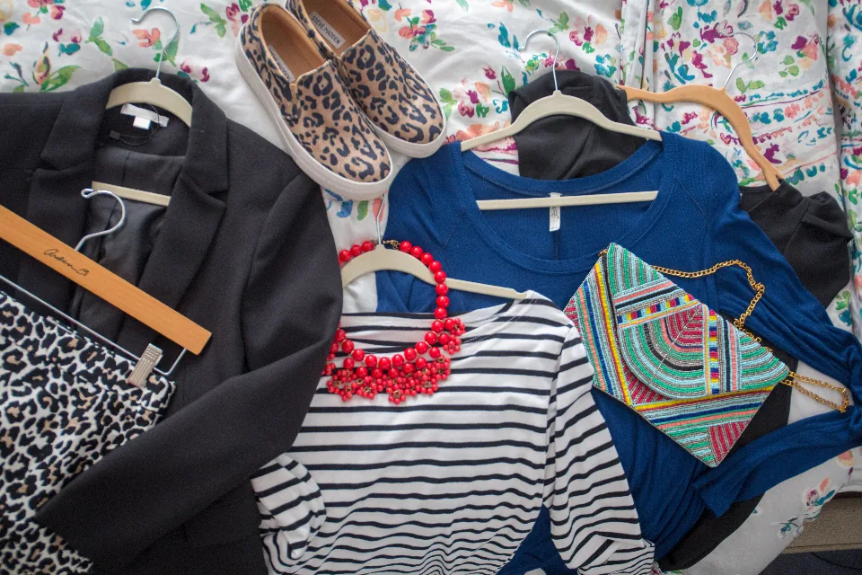 Clothes and shoes laid out on a bed