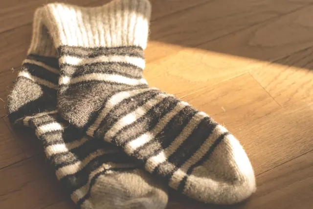Pair of striped wool socks on a wooden floor
